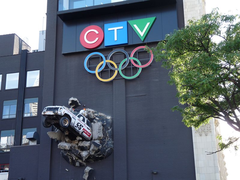 Truck coming out the side of a TV company building