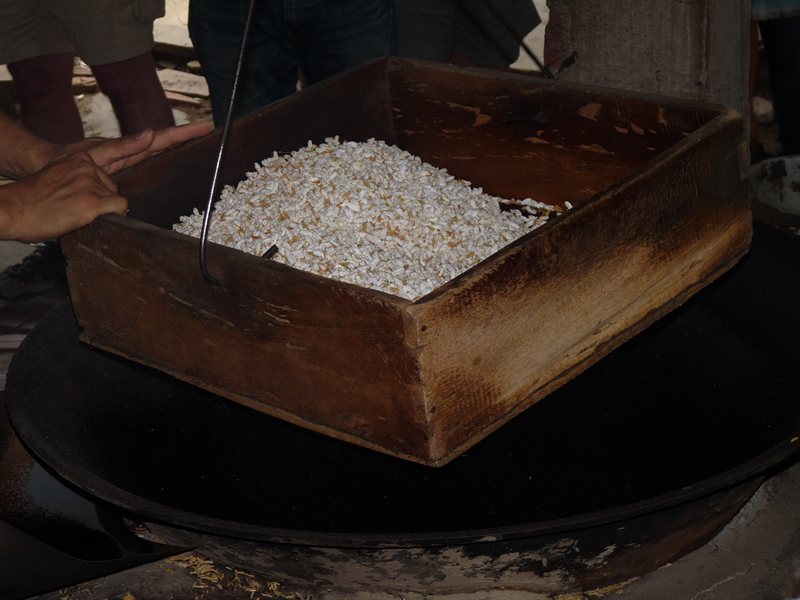 Sieving the hot sand out of the popped corn