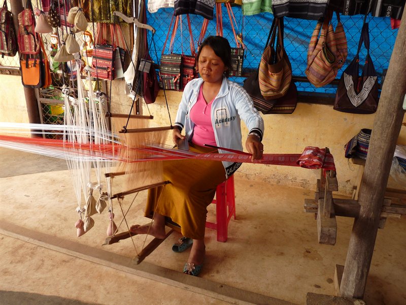 Woman weaving silk and cotton to make table cloths