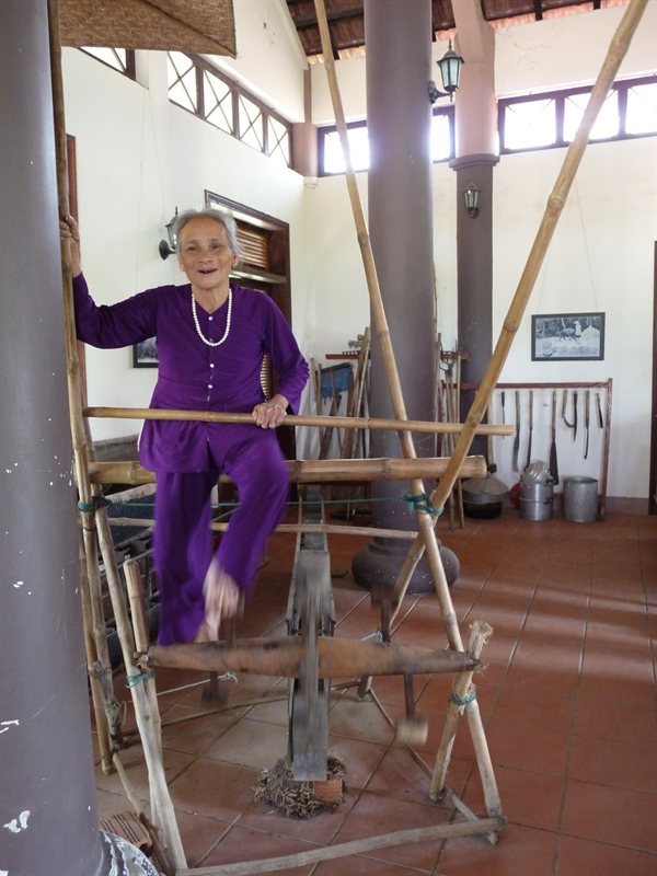 The old lady in the rice museum demonstrating the machine used to get water into the paddy fields
