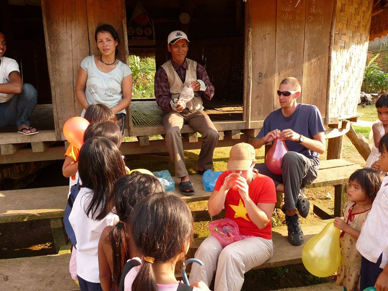 Blowing up balloons for the children in a minority village